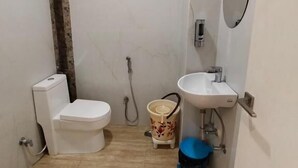 Une petite salle de bain avec des toilettes, un lavabo et une douche.