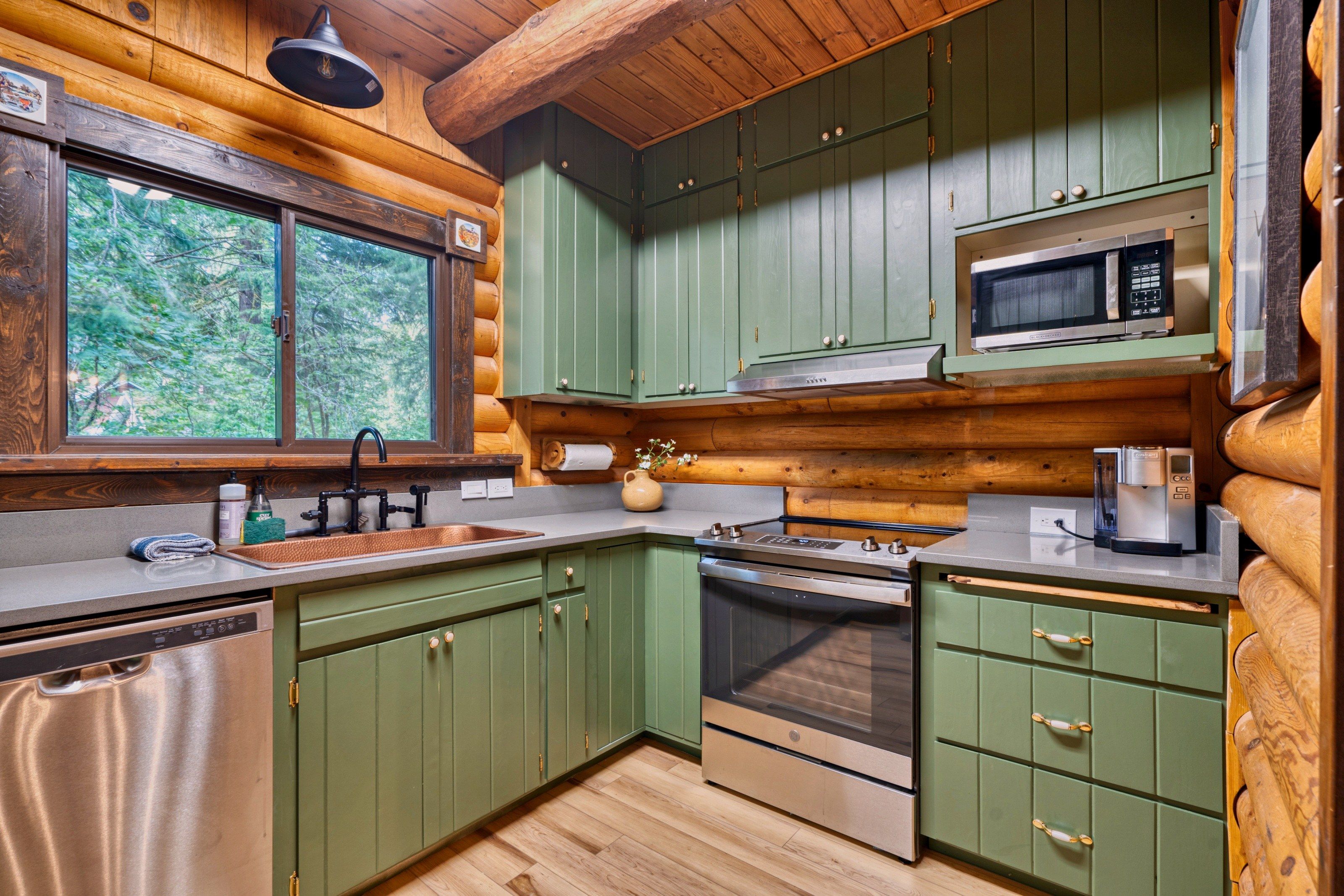 A kitchen with wooden cabinets, a microwave, an oven, and a sink.