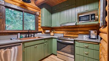 A kitchen with wooden cabinets, a microwave, an oven, and a sink.