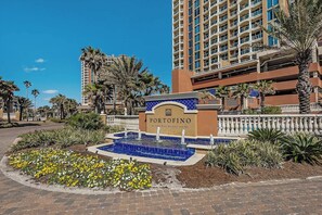 A hotel entrance with a sign reading "PORTOFINO," a fountain, and surrounding palm trees.