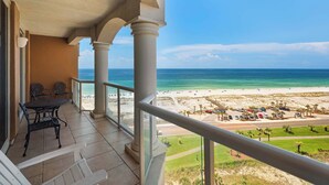 A balcony with a view of the beach and ocean.