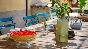 A wooden table with a glass pie dish, a vase with flowers, and a teapot. - La Ritournelle in Provence, 19 people, 4*. (Pernes-les-Fontaines)