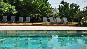 A swimming pool with clear water and a deck area with six lounge chairs. - La Ritournelle in Provence, 19 people, 4*. (Pernes-les-Fontaines)