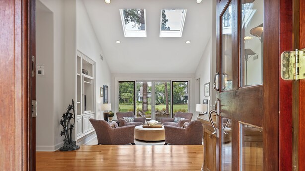 A spacious living room with a round coffee table, two sofas, and a large window with a view of the outdoors.