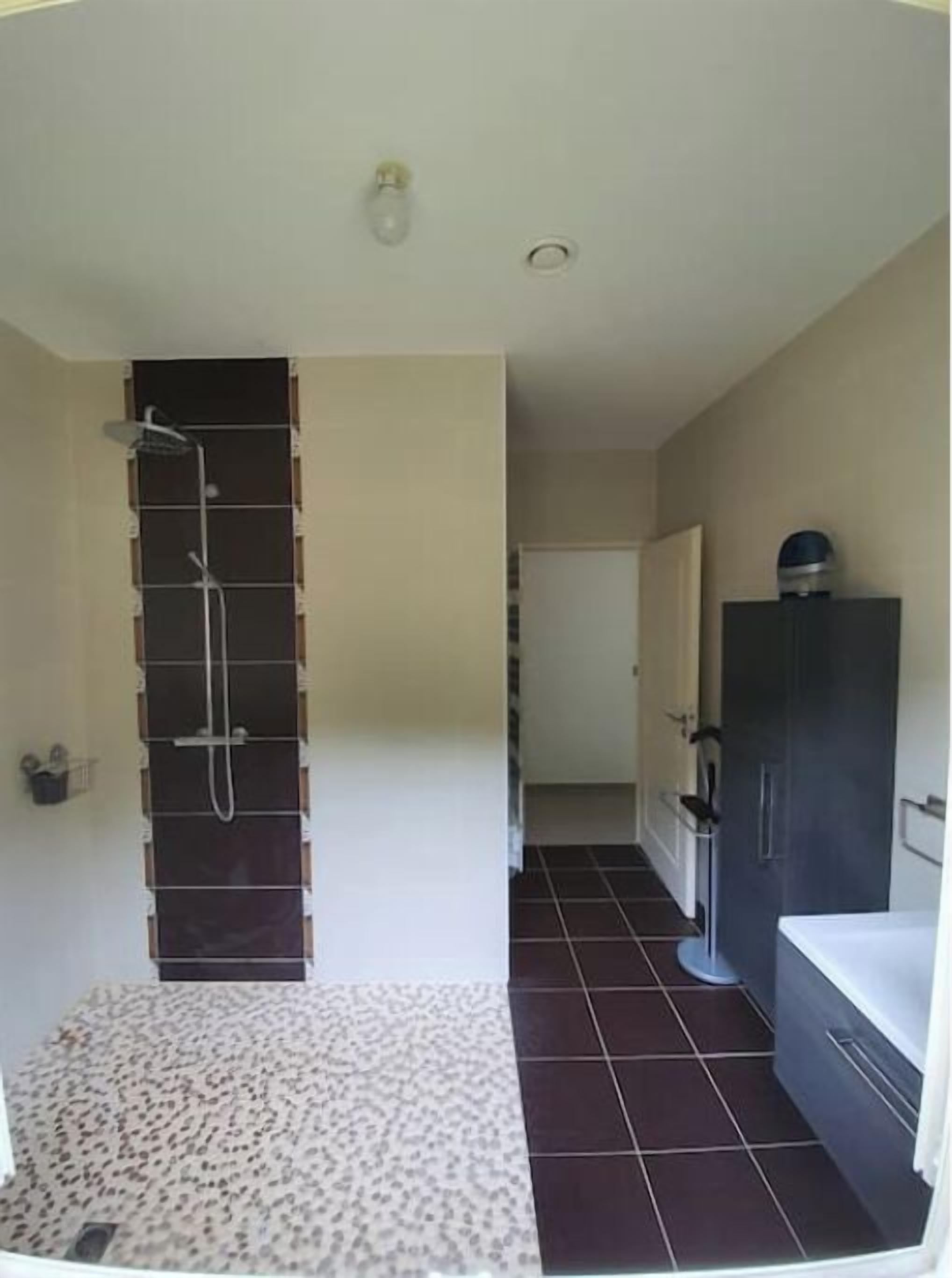 Une salle de bain avec une douche, des toilettes et un lavabo.