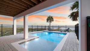 A swimming pool with a view of the beach and sunset. - Large Luxury Beach House with Pool (Port St. Joe)