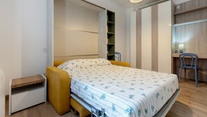 Ein gemütliches Schlafzimmer mit Bett, Schreibtisch und Stuhl.