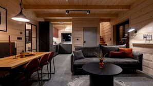 A modern interior with a wooden dining table, red chairs, a grey sofa, and a black coffee table. - RentPlanet - Wierzchołki (Czarny Dunajec)