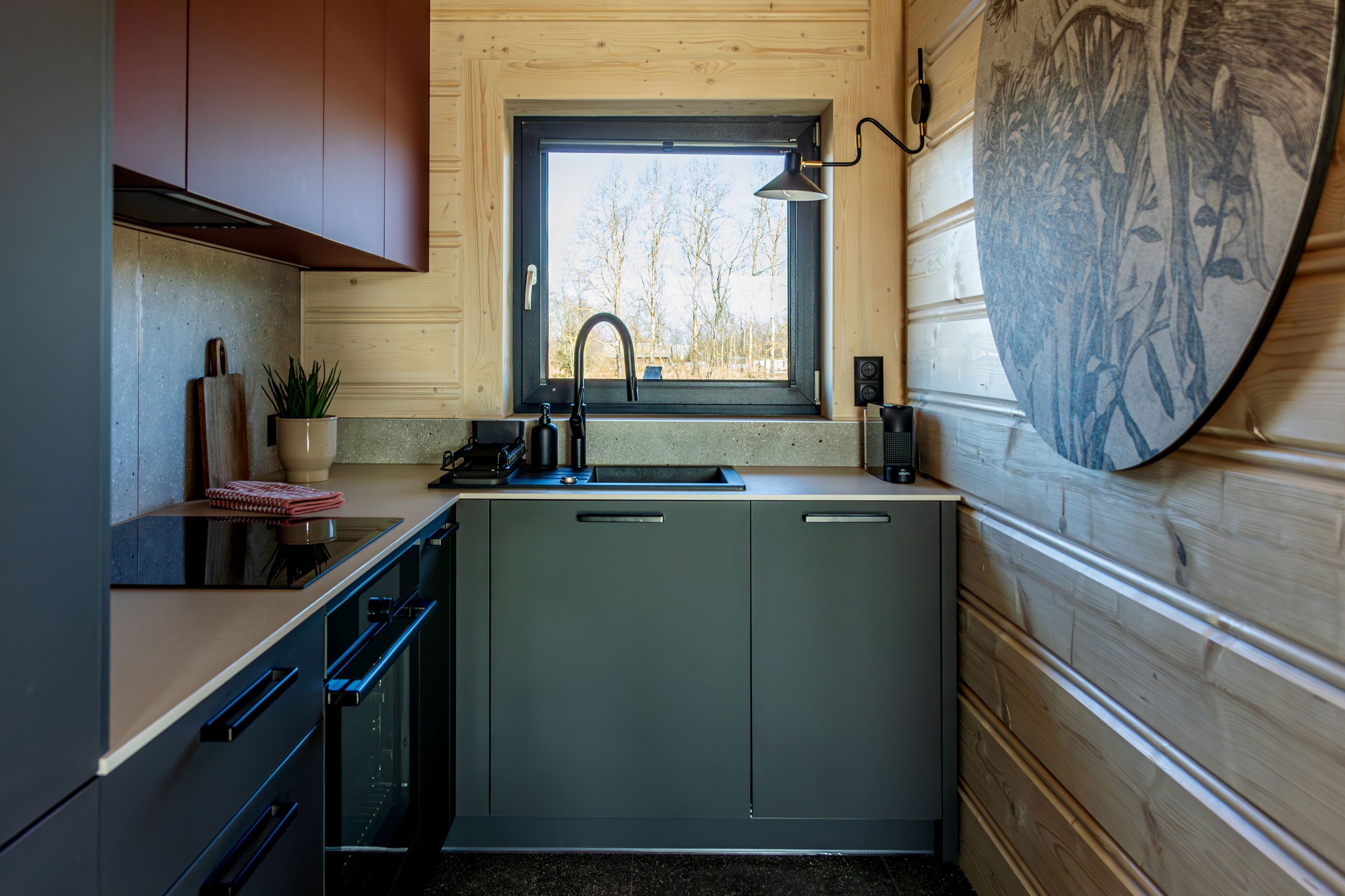 A compact kitchen with a window, a sink, and a stove.