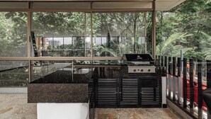 Une cuisine moderne dotée d’une grande fenêtre, d’une cuisinière à gaz et d’un évier.