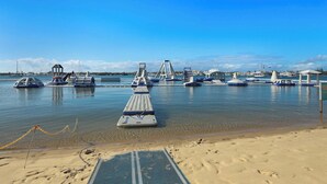 Una marina con barcos, un espigón y una playa arenosa.