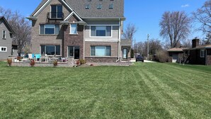 A two-story house with a large front lawn and a garage.