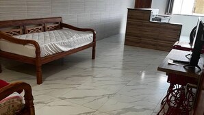 A room with a wooden bed, a desk with a computer, and a reception area. - Hotel Lumiar (Nova Friburgo)