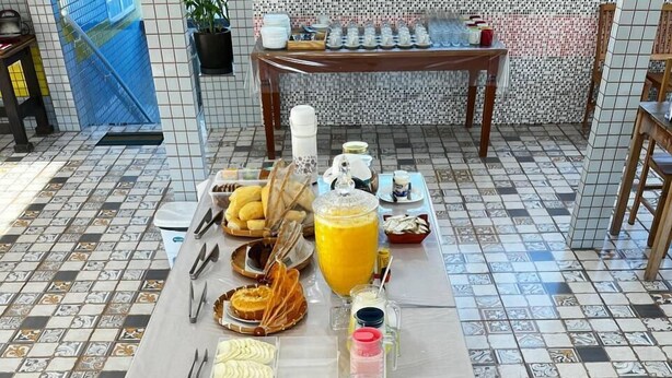 A buffet table with various food items and condiments. - Hotel Lumiar (Nova Friburgo)