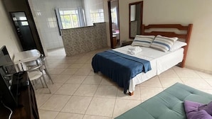 A bedroom with a bed, a desk, and a green sofa. - Hotel Lumiar (Nova Friburgo)