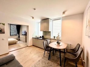 A compact living space with a dining area, kitchenette, and a small seating area. - Apartamenty 1 maja 94 (Katowice)