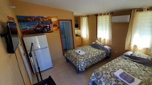 Une chambre d’hôtel avec deux lits, un réfrigérateur, une petite kitchenette et une salle de bain.