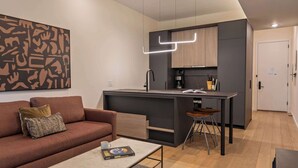 Un appartement moderne comprenant un espace de vie, une kitchenette et un coin repas.