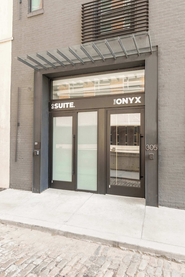 A modern building entrance with a glass door labeled "The Onyx Suite."