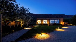 Et moderne hus med grusindkørsel og et godt oplyst interiør.