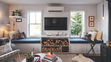 Una Smart TV, una chimenea, libros, un reproductor estéreo