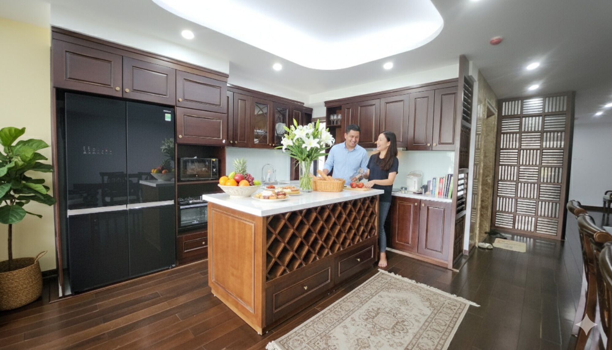 A modern kitchen with dark wooden cabinets, a central island with a wine rack, and a large refrigerator.