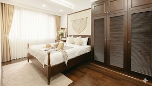 Un dormitorio con cama de madera, un armario grande y un tapiz de macramé en la pared.