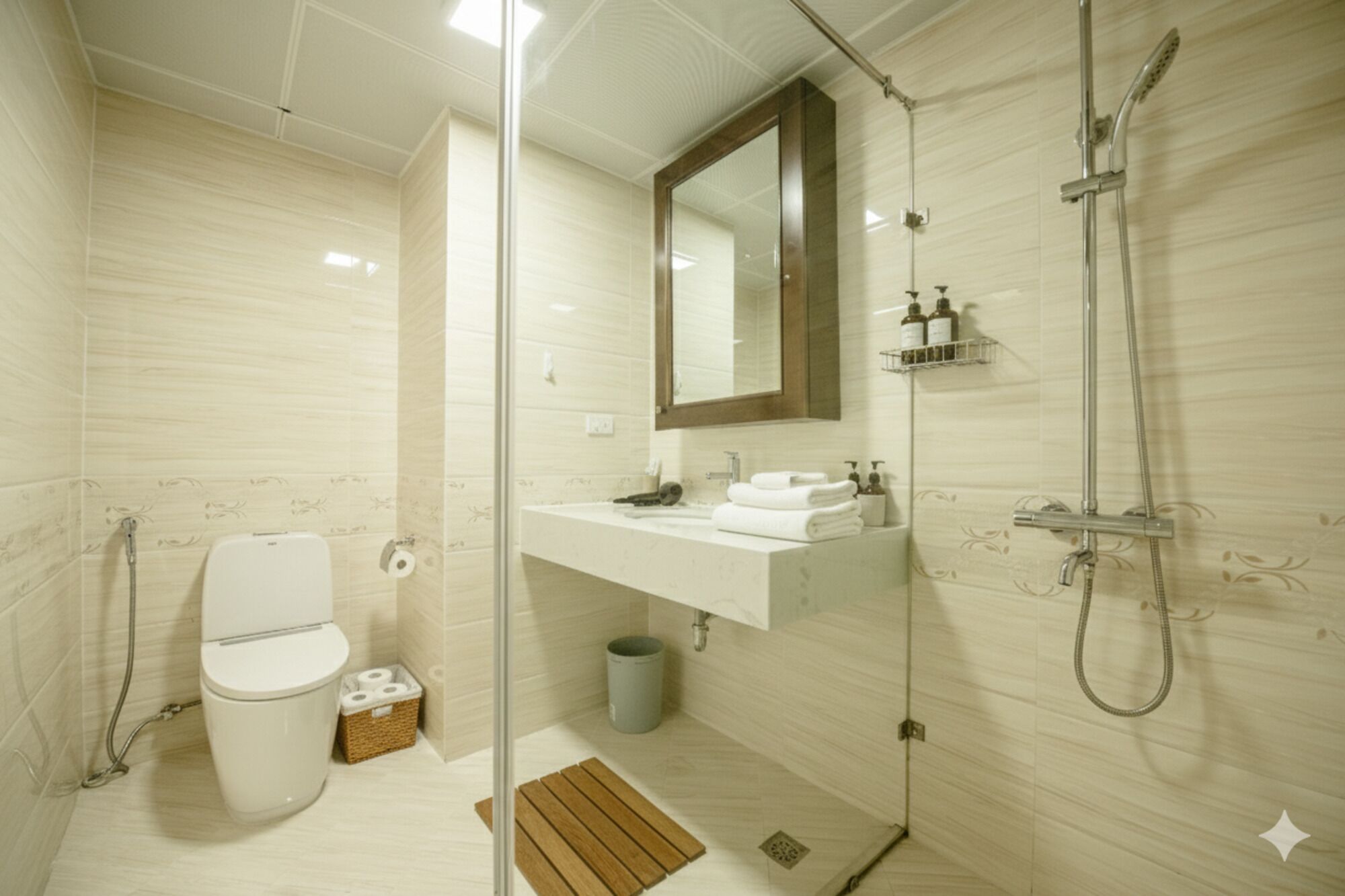 A modern bathroom with a glass shower enclosure, a toilet, a sink with a mirror, and a small trash bin.