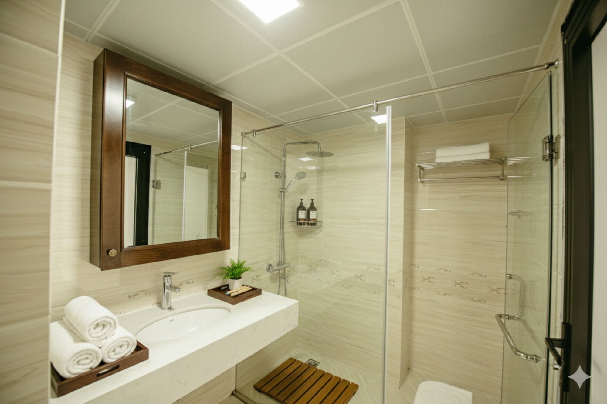 Un baño moderno con cabina de ducha de vidrio, un espejo grande y un lavamanos blanco con artículos de tocador.