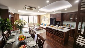 Una cocina moderna con armarios de madera oscura, una isla central y un comedor con una mesa dispuesta para seis.