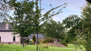 A house with a garden, a lawn, and a statue. - Stylish Woodland Retreat With Balcony Views (Wingfield)