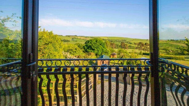 A balcony with a view of a green landscape, including fields and trees. - Stylish Woodland Retreat With Balcony Views (Wingfield)