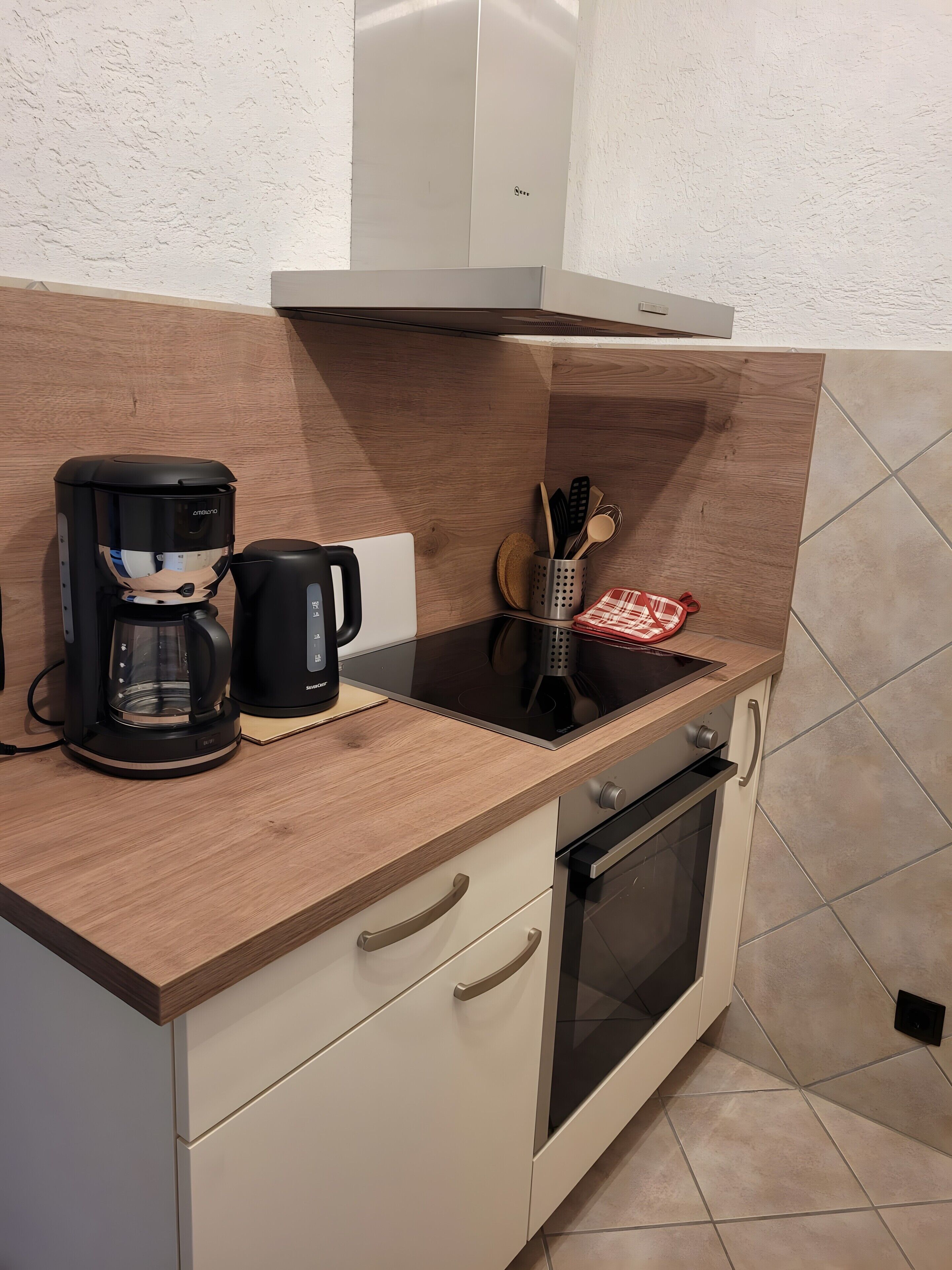 Une petite cuisine équipée d’une machine à café, d’un grille-pain, d’un bloc à couteaux et d’un four à micro-ondes.