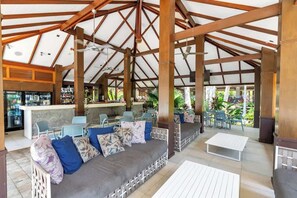 Un'area relax all'aperto con posti a sedere imbottiti, un bar e vista sul verde.