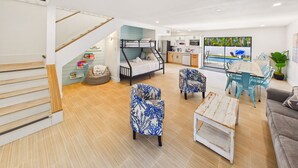 Un salon moderne avec un lit superposé, un coin repas avec vue sur la piscine et une cuisine.
