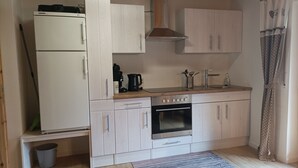 Uma cozinha compacta com geladeira, fogão e pia.