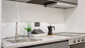 Une cuisine moderne dotée d’appareils électroménagers en acier inoxydable, d’un plan de travail en granit et d’un four encastré.