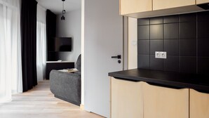 Een moderne keuken met zwarte aanrechtbladen, houten kastjes en een betegelde spatwand.
