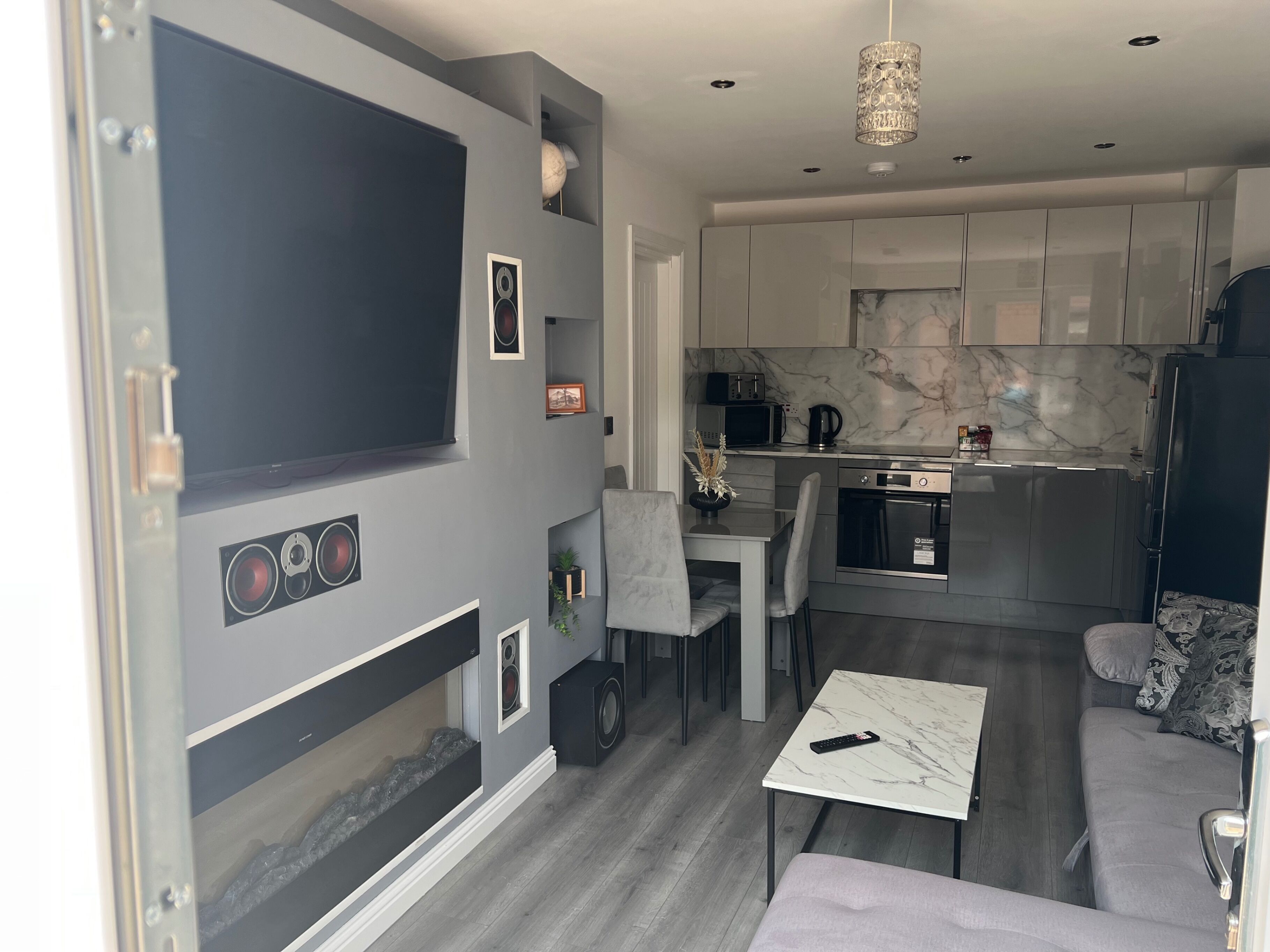 Een compacte leefruimte met een kitchenette, een eethoek en een zithoek.