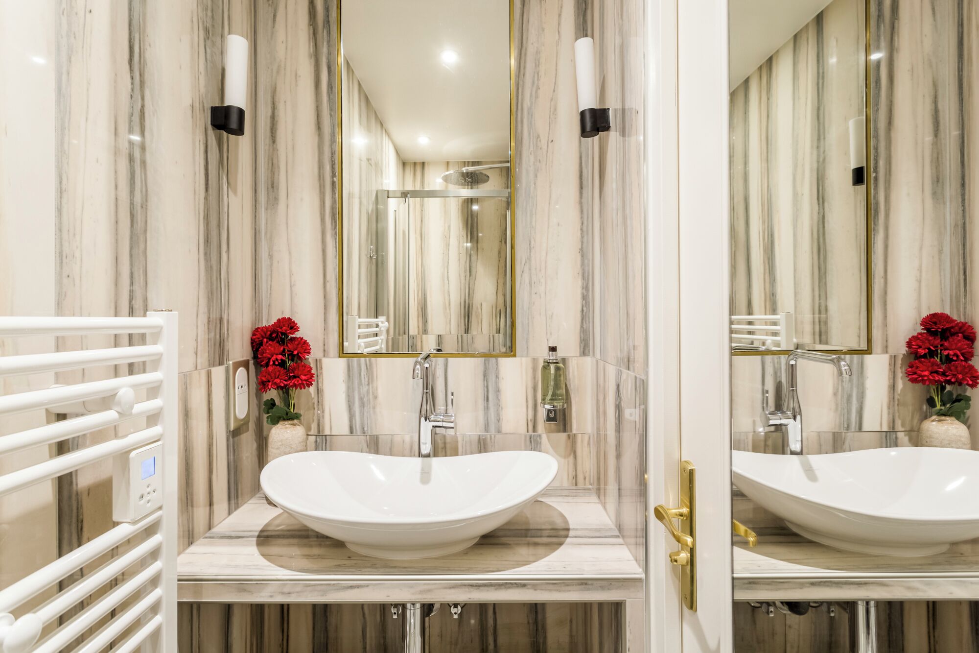 A bathroom with a large, oval sink, a mirror, and a shower.