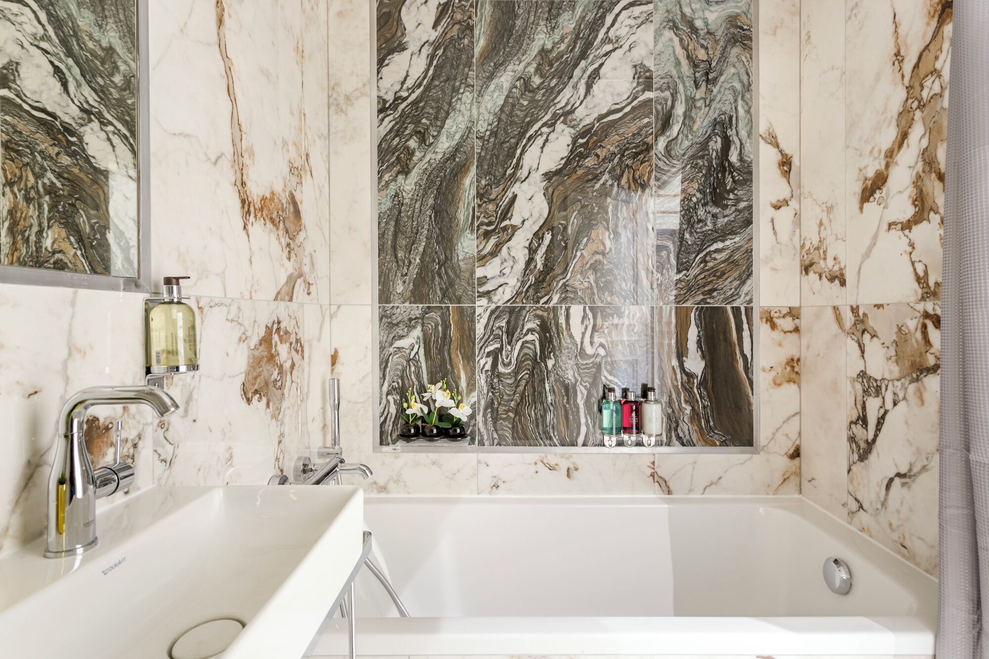 Une salle de bain avec une grande baignoire, un double lavabo et un miroir.
