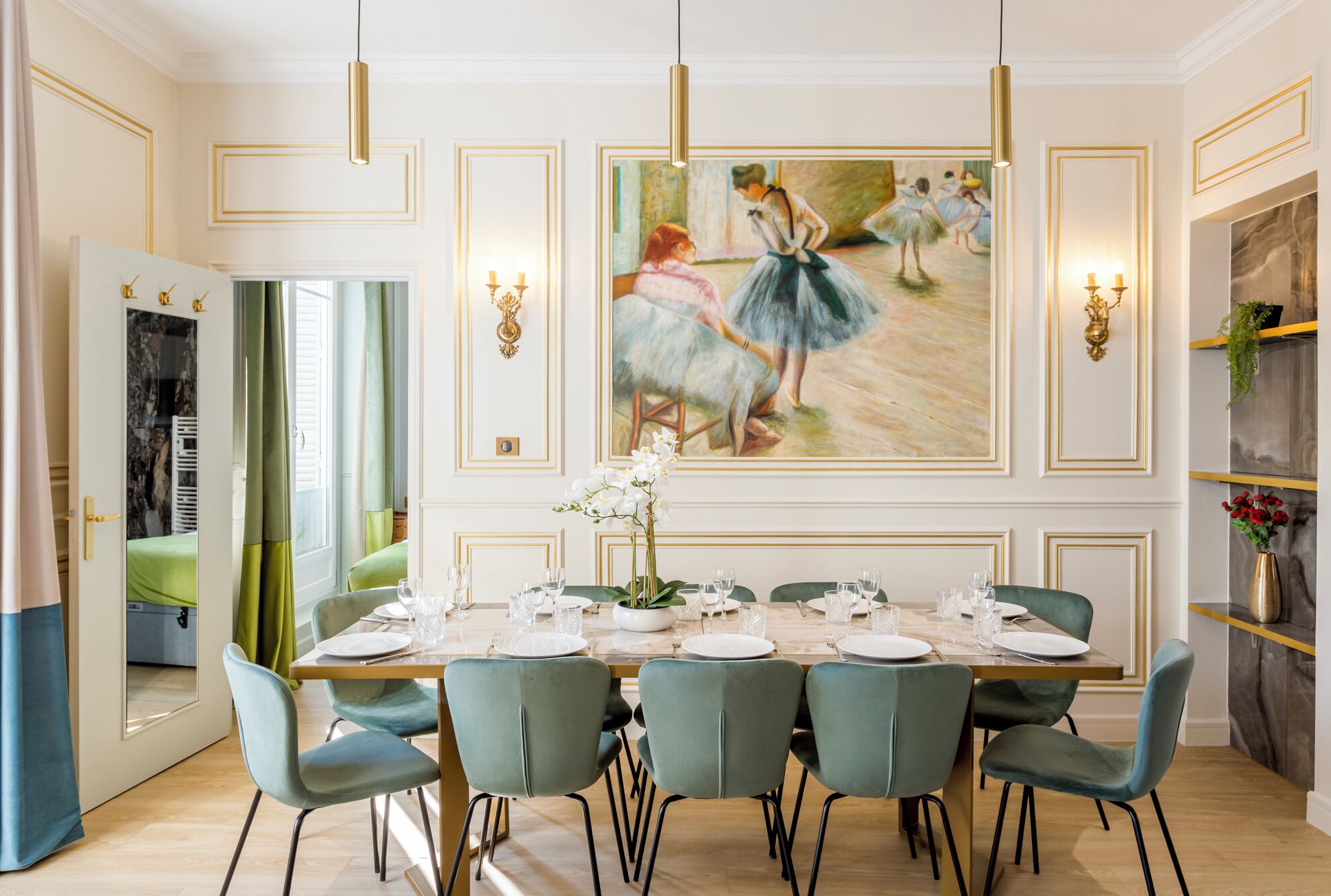 A dining room with a long table set for six, green upholstered chairs, and a large painting of ballerinas on the wall.