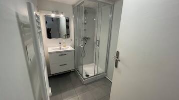 Een douche, een haardroger, handdoeken, toiletpapier