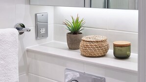 A bathroom with a white sink, a potted plant, a woven basket, and a jar. - Student Only Cumberland Place (Southampton)