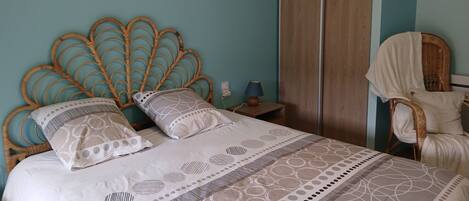 A bedroom with a bed, a nightstand, a chair, and a wardrobe.