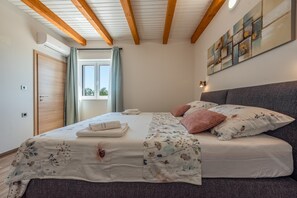 A bedroom with a bed, a window, a door, and a wall-mounted light fixture. - Villa Rosea Domus ZadarVillas (Podlug)