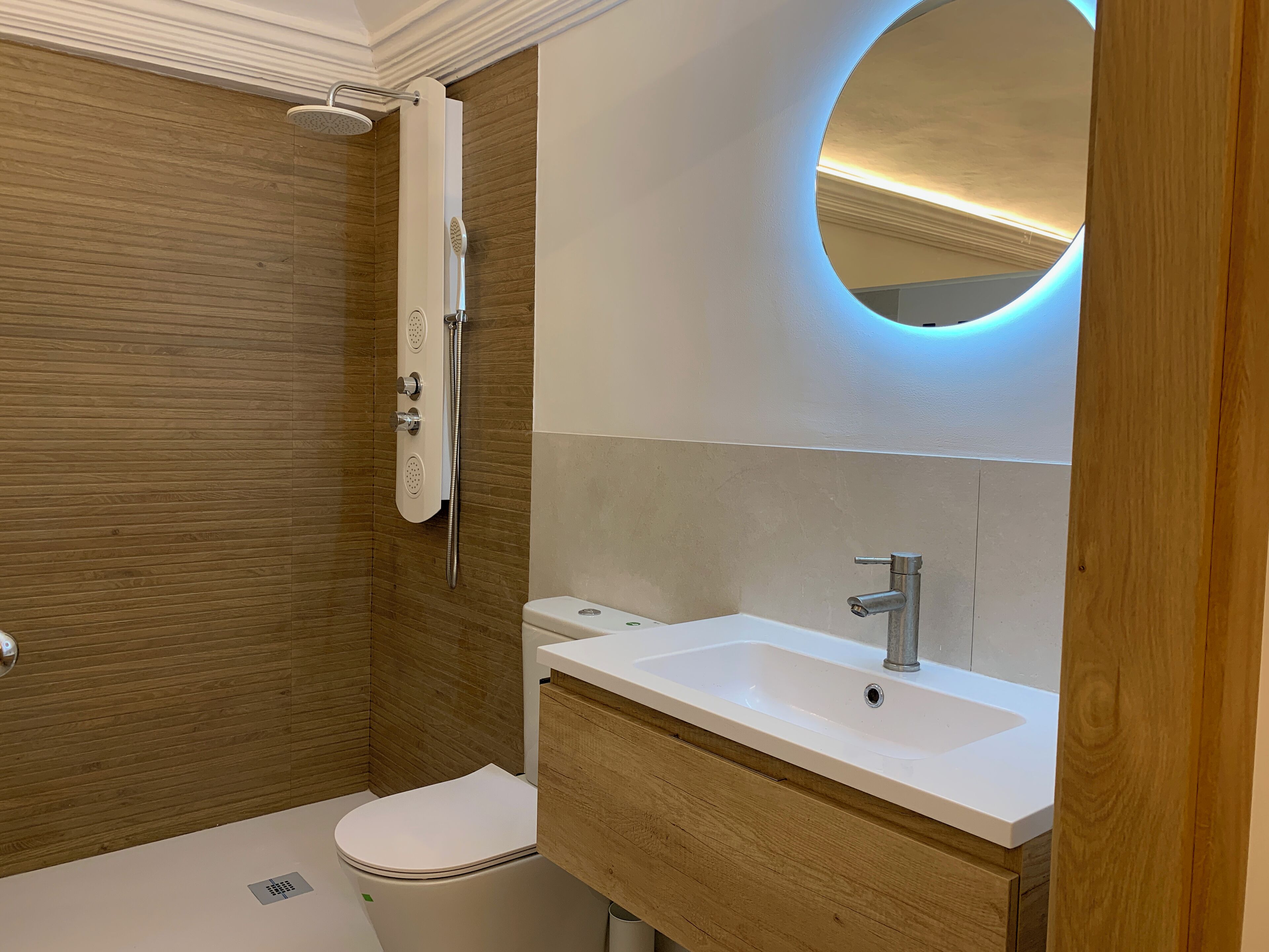 A modern bathroom with a shower, toilet, and sink.
