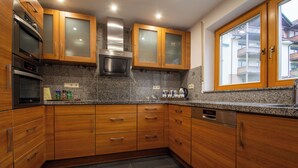 A modern kitchen with wooden cabinets, granite countertops, and stainless steel appliances. - New vacation apartment in Sigmaringen, 15 minutes' walk to the pedestrian zone. (Sigmaringen)