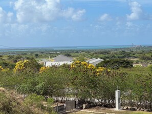 Un paysage côtier offrant une vue sur la mer, un pont et un bâtiment doté d’un toit plat.