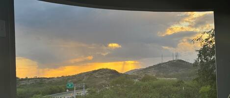 A view from a window overlooking a landscape with hills, a road, and a sign for 'Salina St' and 'Aguirre'.